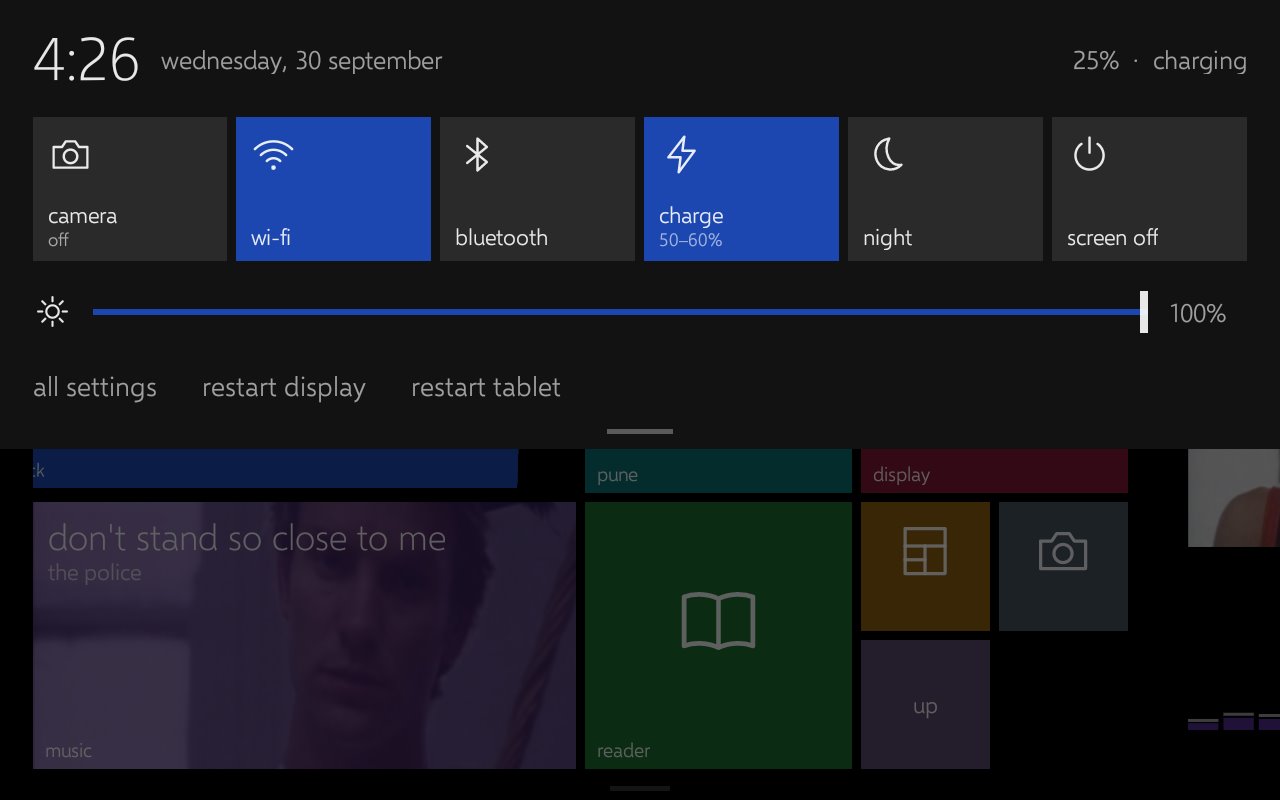 A dark quick settings panel pulled down over the home screen, with tiles for camera, wi-fi, bluetooth, charge, night and screen off.
